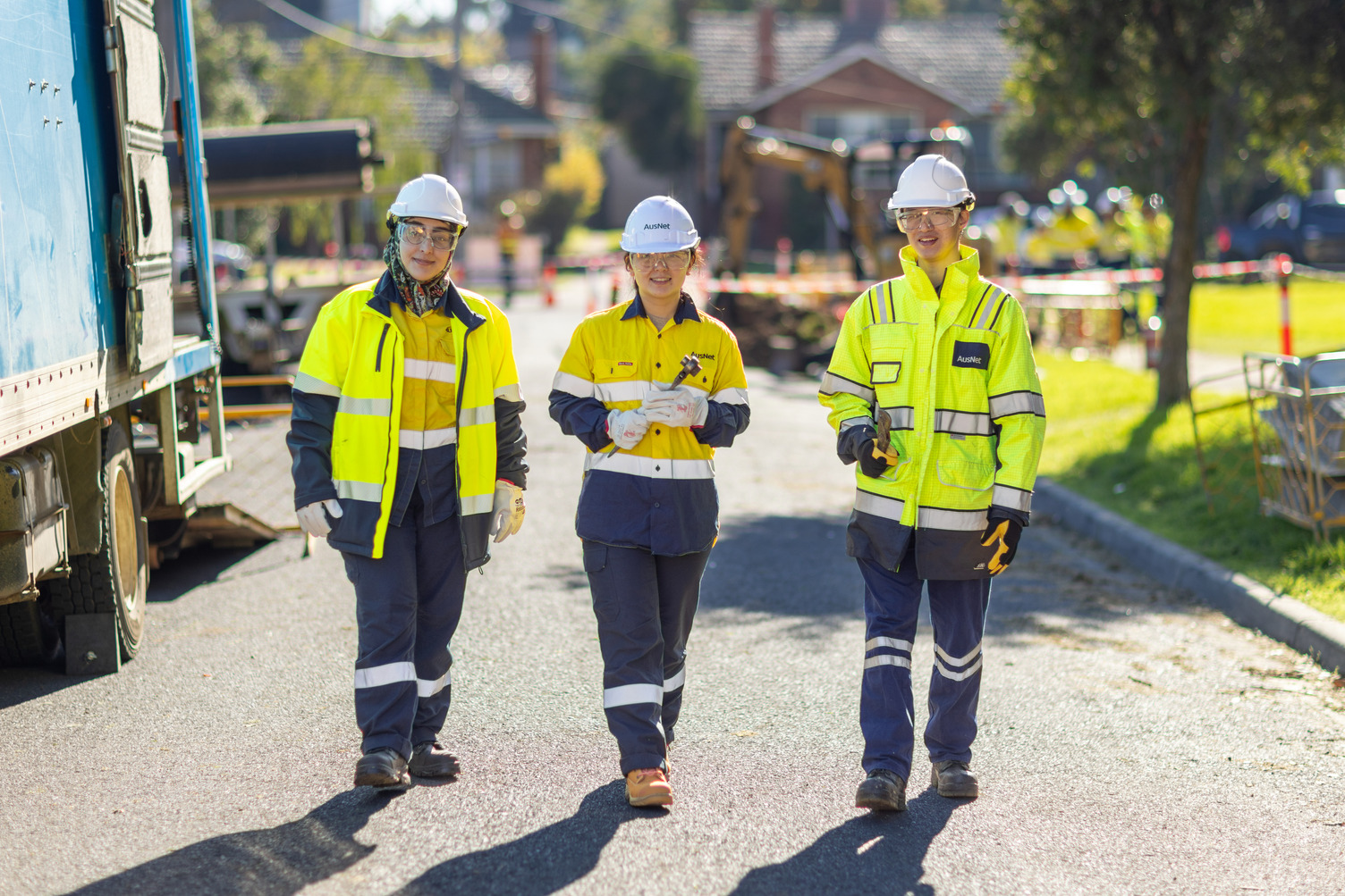 A group of gas workers in high vis walking along a street