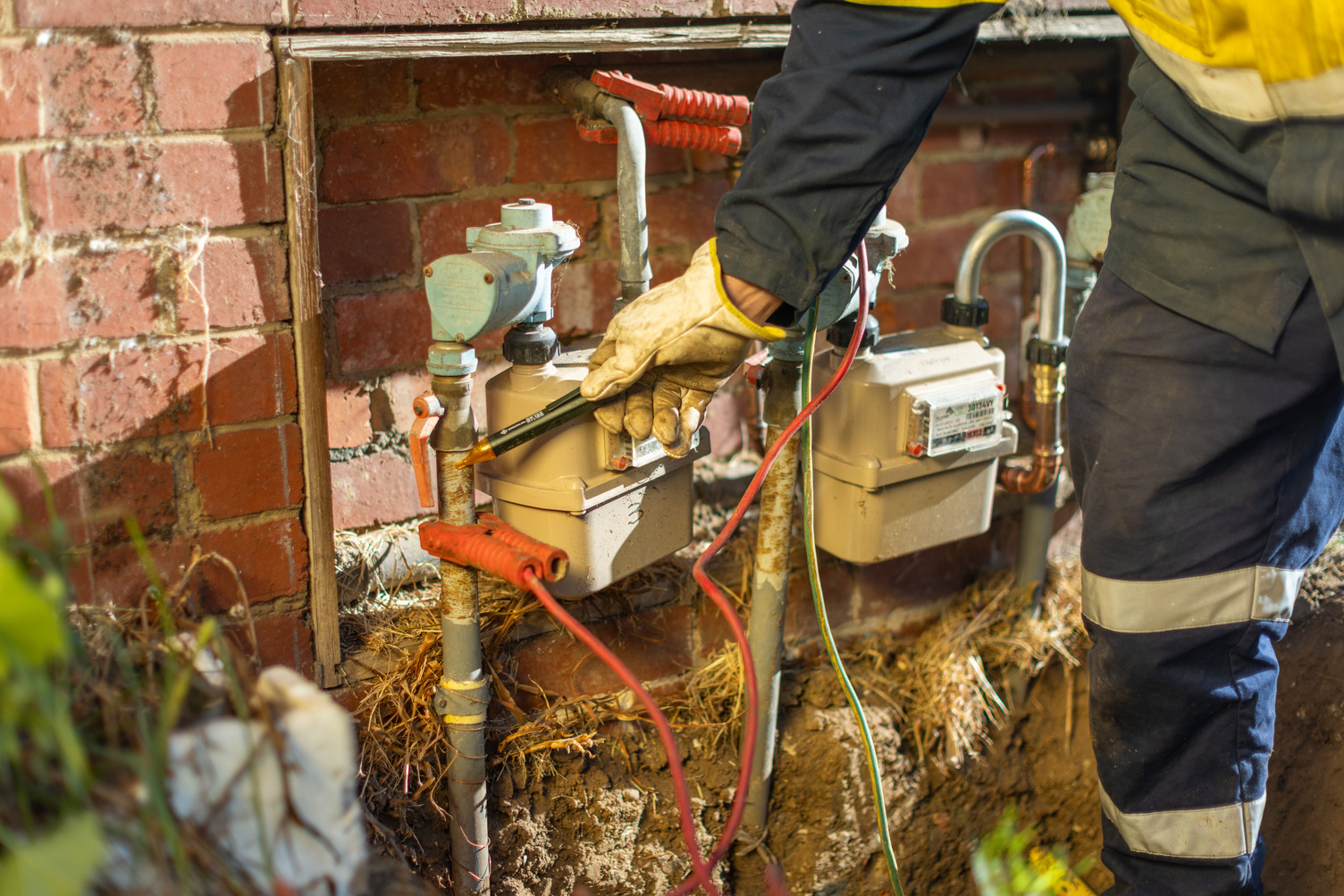 A person in high vis working on a gas meter