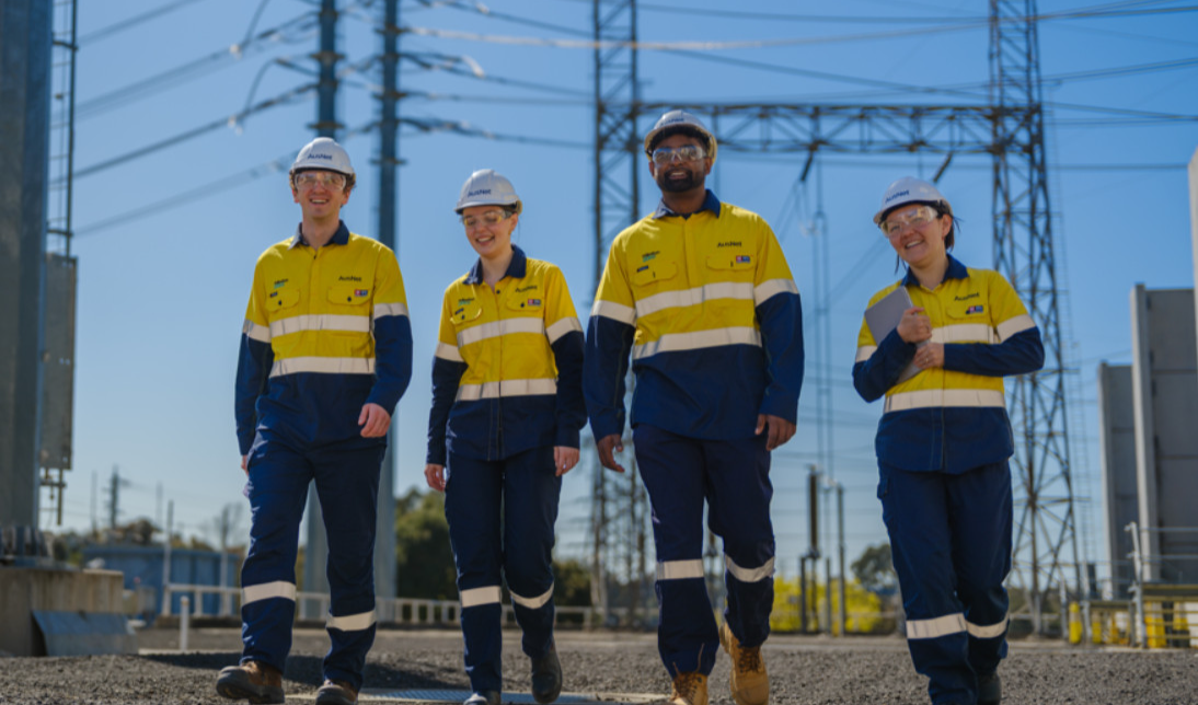 Four workers outside, wearing high vis and walking together