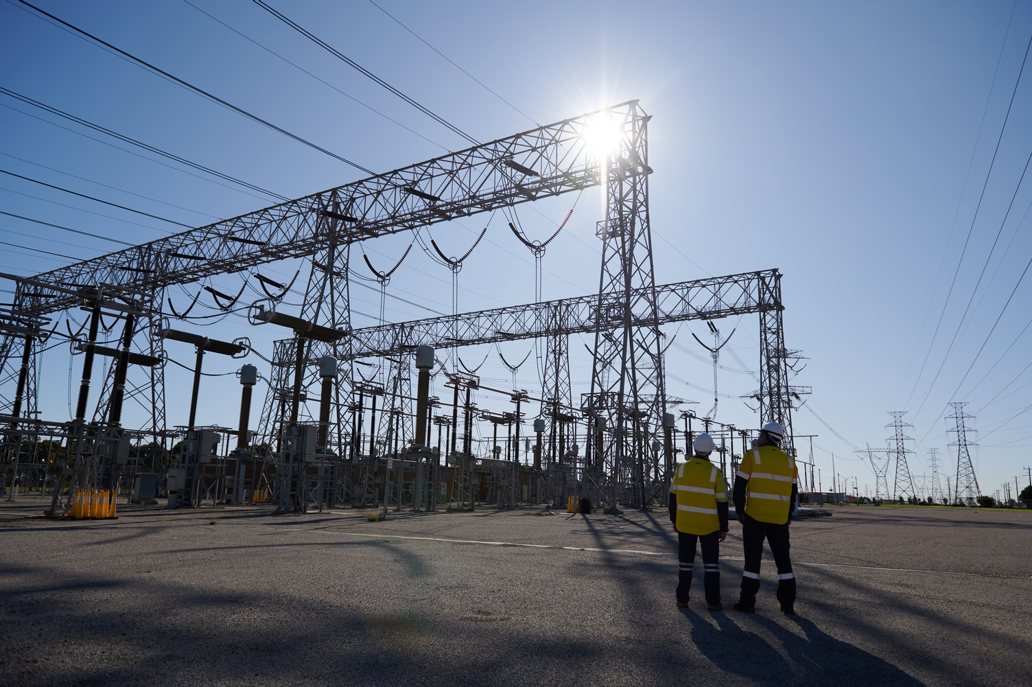 Two workers in highvis stand near a large terminal station